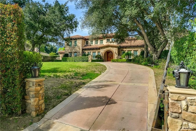 mediterranean / spanish-style house featuring a front lawn