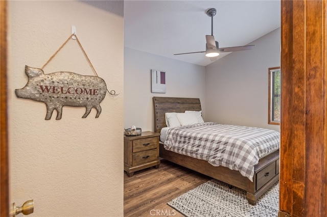 bedroom featuring hardwood / wood-style flooring, vaulted ceiling, and ceiling fan