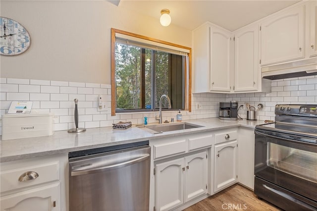 kitchen featuring sink, white cabinets, decorative backsplash, stainless steel dishwasher, and black range with electric stovetop