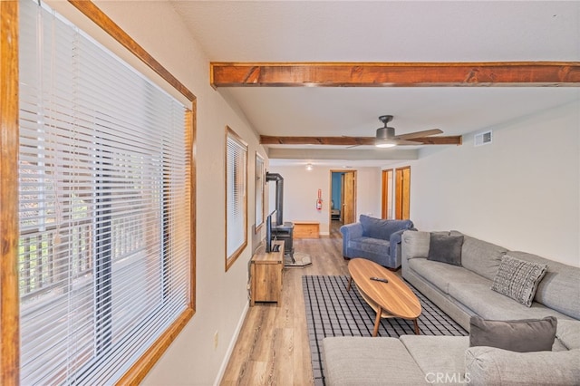 living room featuring beam ceiling, light hardwood / wood-style flooring, and ceiling fan