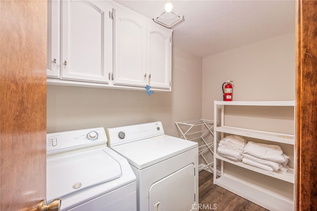 laundry room with cabinets, dark hardwood / wood-style floors, and washer and dryer