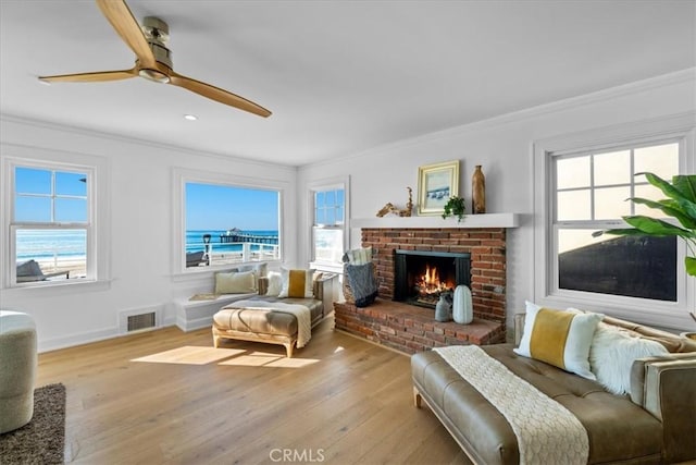 interior space with light wood-type flooring, a water view, and a healthy amount of sunlight