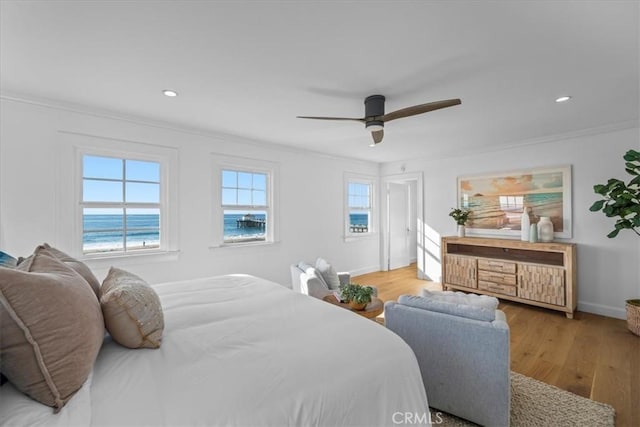 bedroom featuring a water view, crown molding, ceiling fan, and light hardwood / wood-style floors