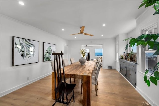 dining room with ceiling fan, light wood-type flooring, and ornamental molding