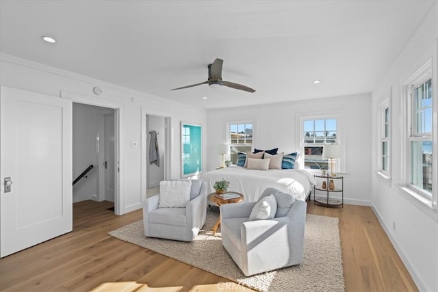 bedroom featuring ceiling fan, light hardwood / wood-style floors, and crown molding