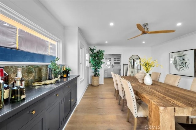 dining area with light hardwood / wood-style floors, ceiling fan, and ornamental molding