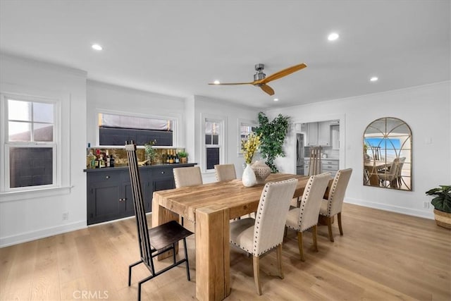 dining room with light hardwood / wood-style flooring, ceiling fan, and crown molding