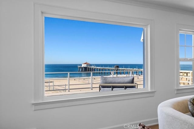 interior space featuring a view of the beach, a water view, and ornamental molding