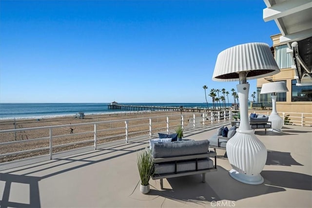 view of patio / terrace with a water view and a view of the beach