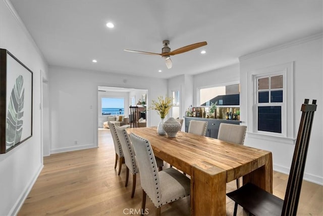 dining room with ceiling fan, a healthy amount of sunlight, light hardwood / wood-style floors, and crown molding