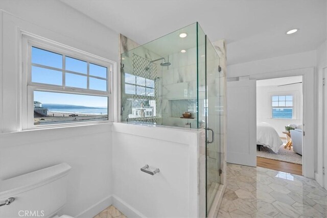 bathroom with toilet and an enclosed shower