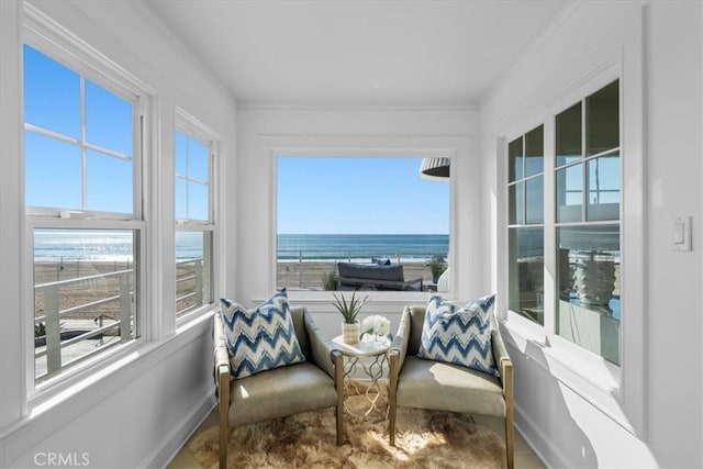 sunroom / solarium with a water view, a healthy amount of sunlight, and a beach view