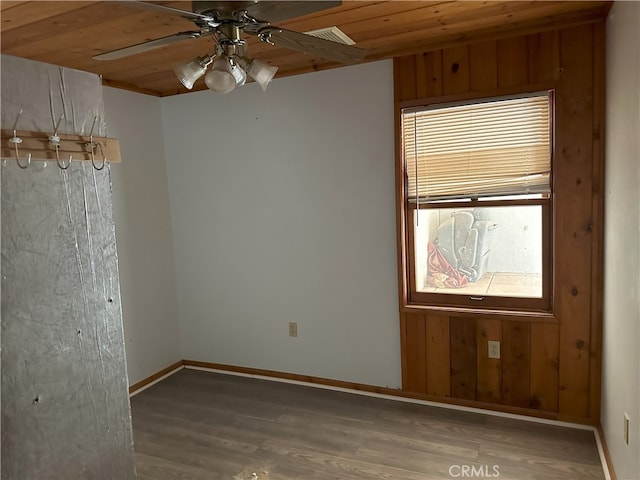 empty room featuring ceiling fan, wood ceiling, a wealth of natural light, and hardwood / wood-style floors