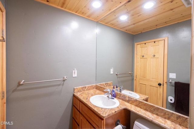 bathroom featuring vanity, wood ceiling, and toilet