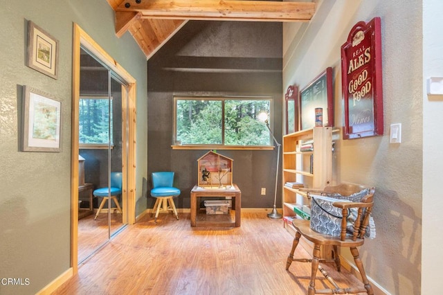 living area featuring hardwood / wood-style floors and lofted ceiling with beams