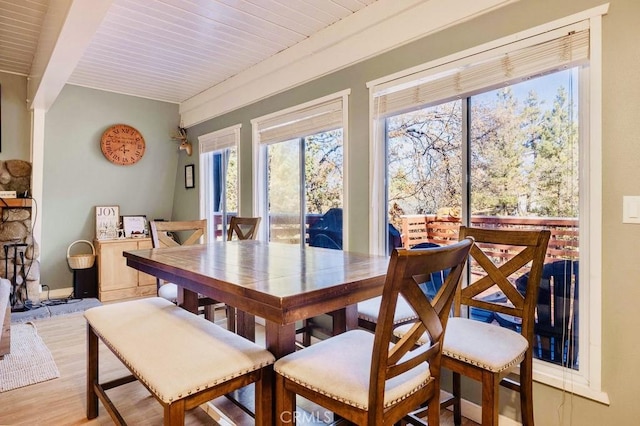 dining room featuring beam ceiling and light hardwood / wood-style flooring