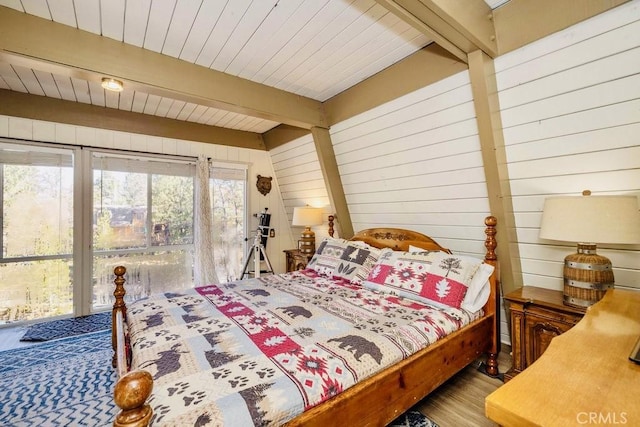 bedroom featuring wood-type flooring, beamed ceiling, and wood walls