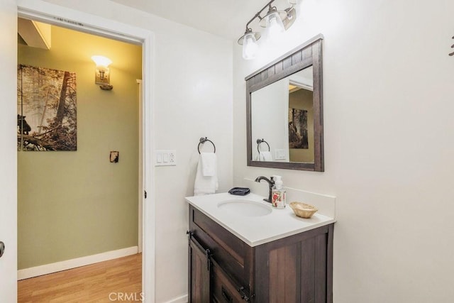 bathroom with vanity, baseboards, and wood finished floors