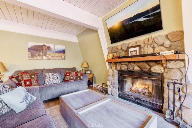 living room with wood-type flooring, a fireplace, and beamed ceiling