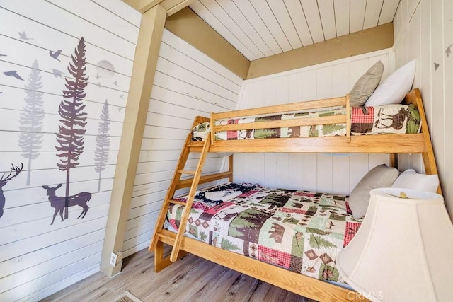 bedroom with wood-type flooring and wood walls