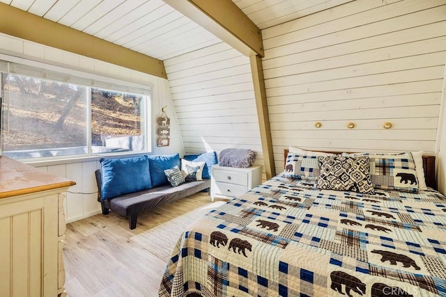 bedroom with light hardwood / wood-style flooring and wood walls