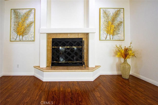 interior details featuring hardwood / wood-style flooring and a tile fireplace