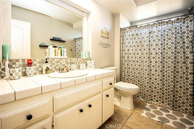 bathroom with toilet, vanity, tile patterned floors, and backsplash