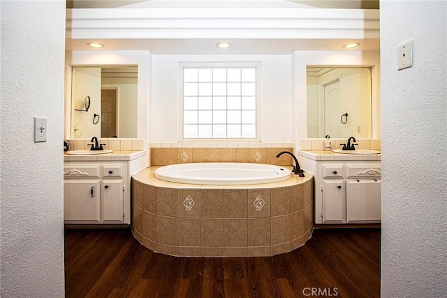 bathroom featuring hardwood / wood-style floors, vanity, and tiled bath