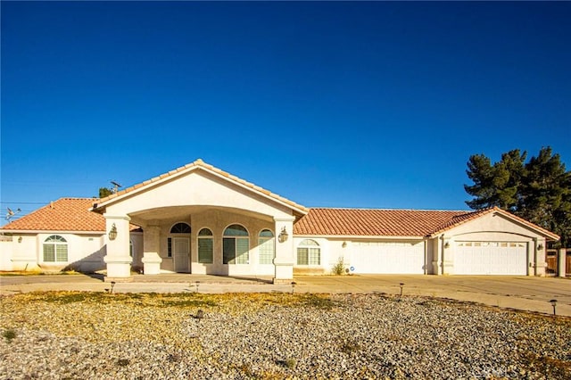 mediterranean / spanish home featuring covered porch and a garage