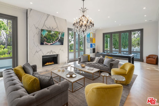 living room featuring crown molding, a fireplace, light parquet floors, and a healthy amount of sunlight