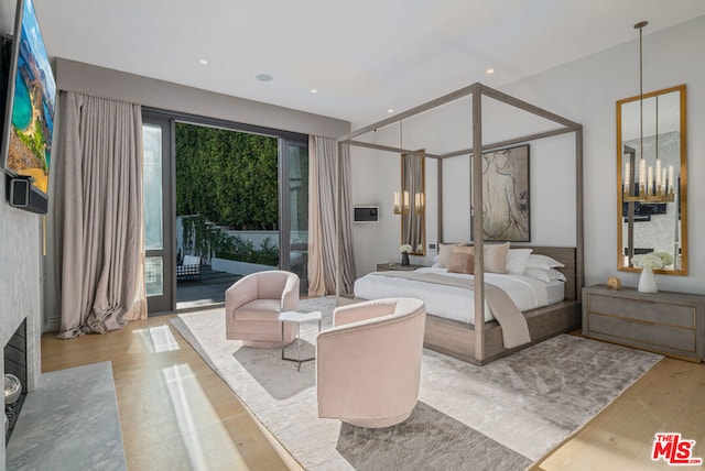 bedroom with access to exterior and light wood-type flooring