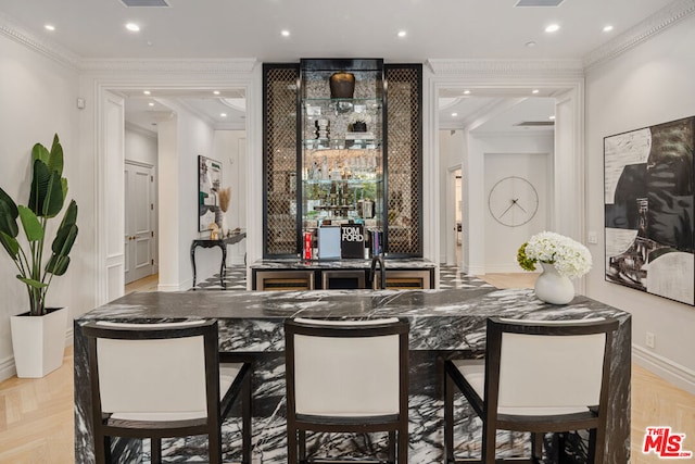 bar featuring ornamental molding and light parquet flooring