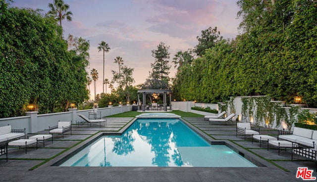 pool at dusk featuring a patio