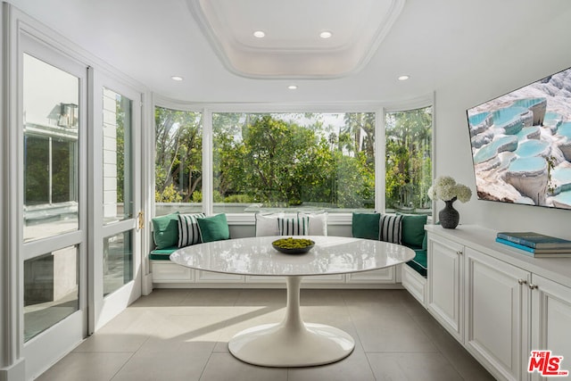 sunroom featuring breakfast area and a tray ceiling