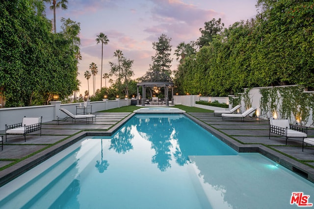 pool at dusk with a wooden deck