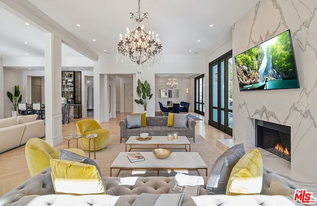 living room with a premium fireplace, crown molding, light parquet floors, and a notable chandelier