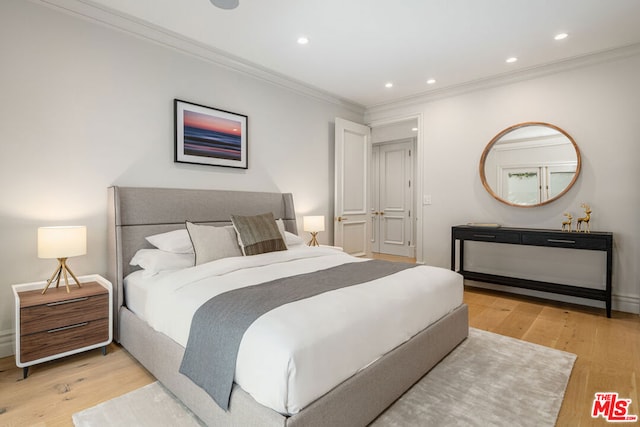 bedroom with crown molding and light hardwood / wood-style flooring