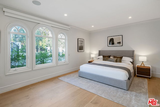 bedroom featuring crown molding and light wood-type flooring