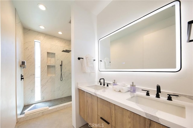 bathroom featuring vanity, a healthy amount of sunlight, and tiled shower