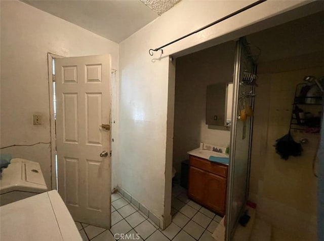 clothes washing area featuring sink, light tile patterned flooring, and washer / dryer