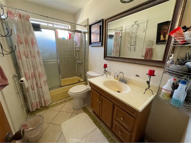 full bathroom with combined bath / shower with glass door, vanity, tile patterned floors, and toilet