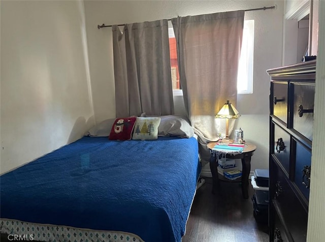 bedroom with dark hardwood / wood-style floors