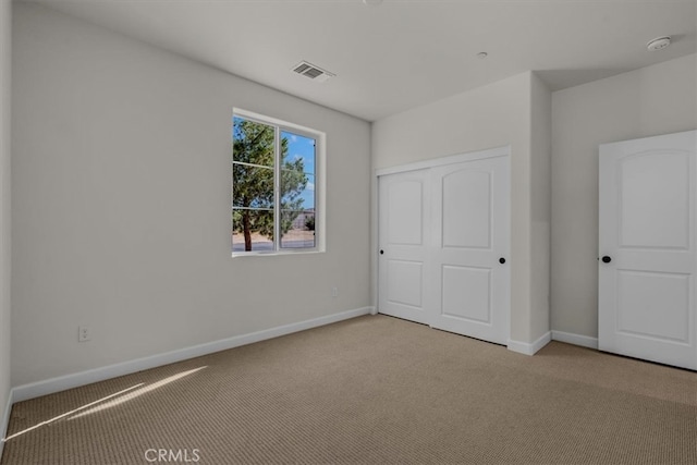 unfurnished bedroom with a closet and light carpet