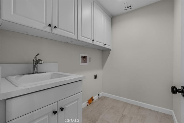 laundry room featuring electric dryer hookup, light hardwood / wood-style flooring, hookup for a washing machine, sink, and cabinets