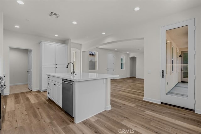 kitchen featuring white cabinets, a kitchen island with sink, light wood-type flooring, stainless steel appliances, and sink