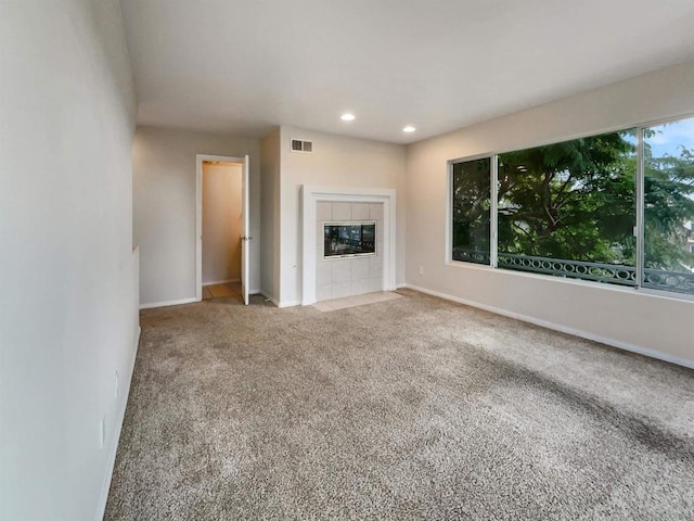 unfurnished living room with carpet floors and a fireplace