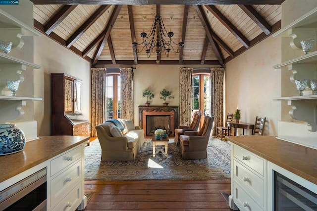 living room with beamed ceiling, dark wood-type flooring, a chandelier, and beverage cooler