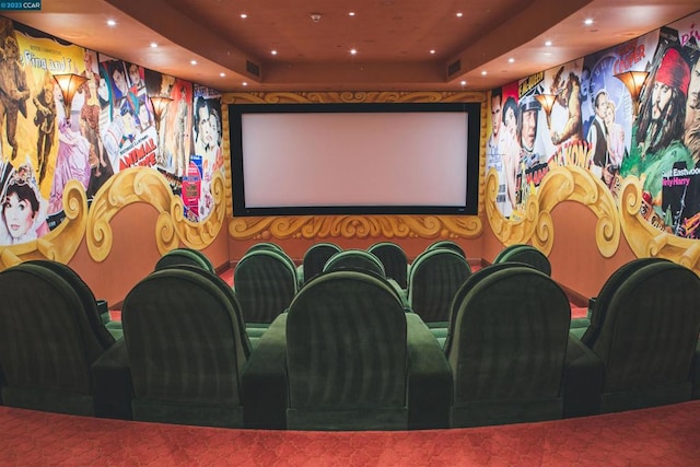 home theater featuring a raised ceiling and carpet flooring