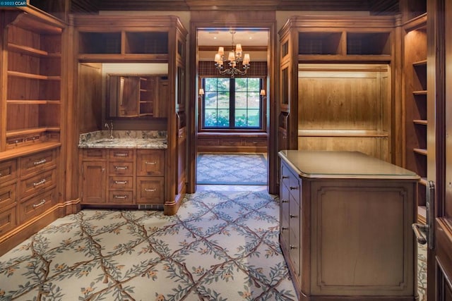 interior space with a chandelier, crown molding, and pendant lighting