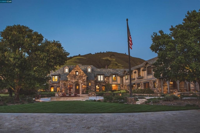 back of property featuring a mountain view and a yard